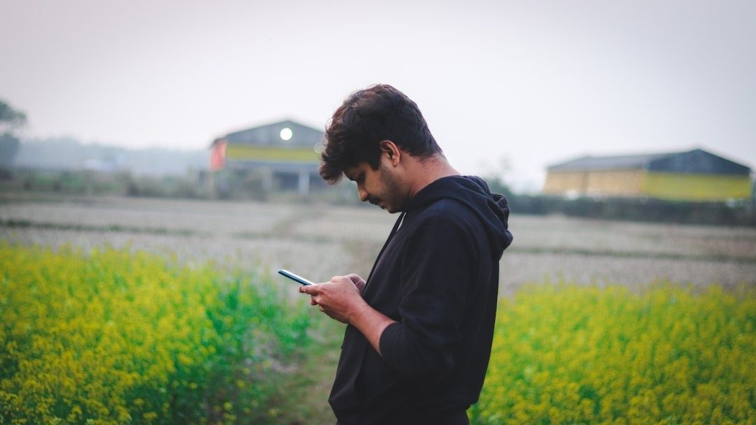 Farmer using a smartphone in a flowering field